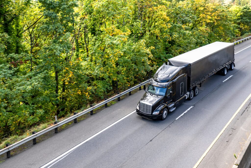 Semi-truck with flatbed trailer on coastal highway